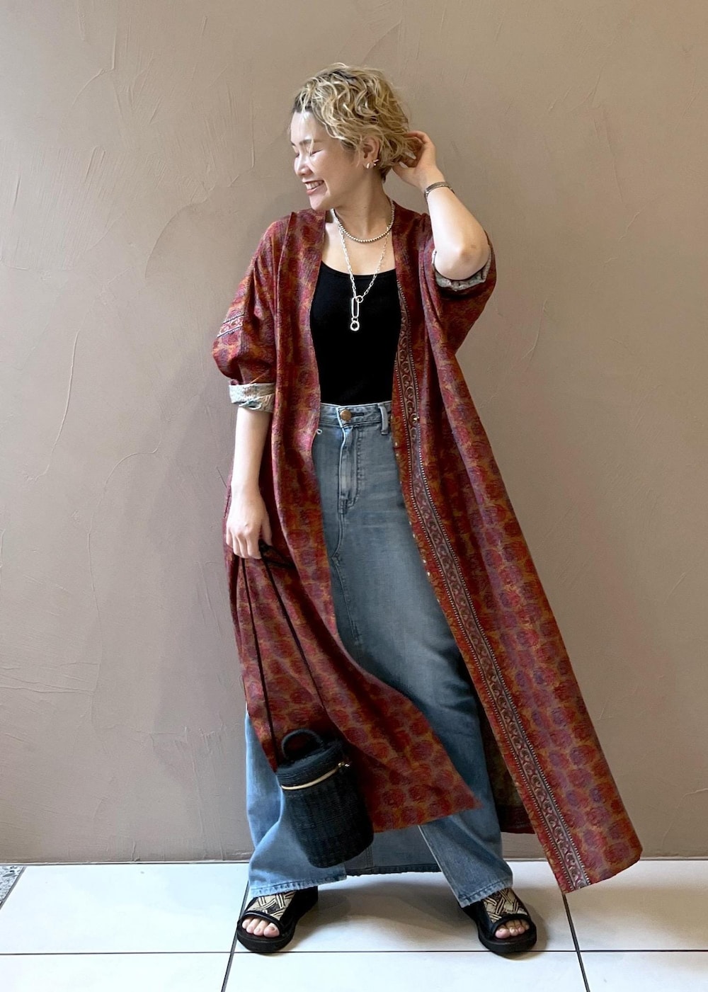 ブラック系のショルダーバッグ、ブラック系のタンクトップ、ブルー系のデニムスカートを着用したレディースの春コーディネートの4枚目の写真