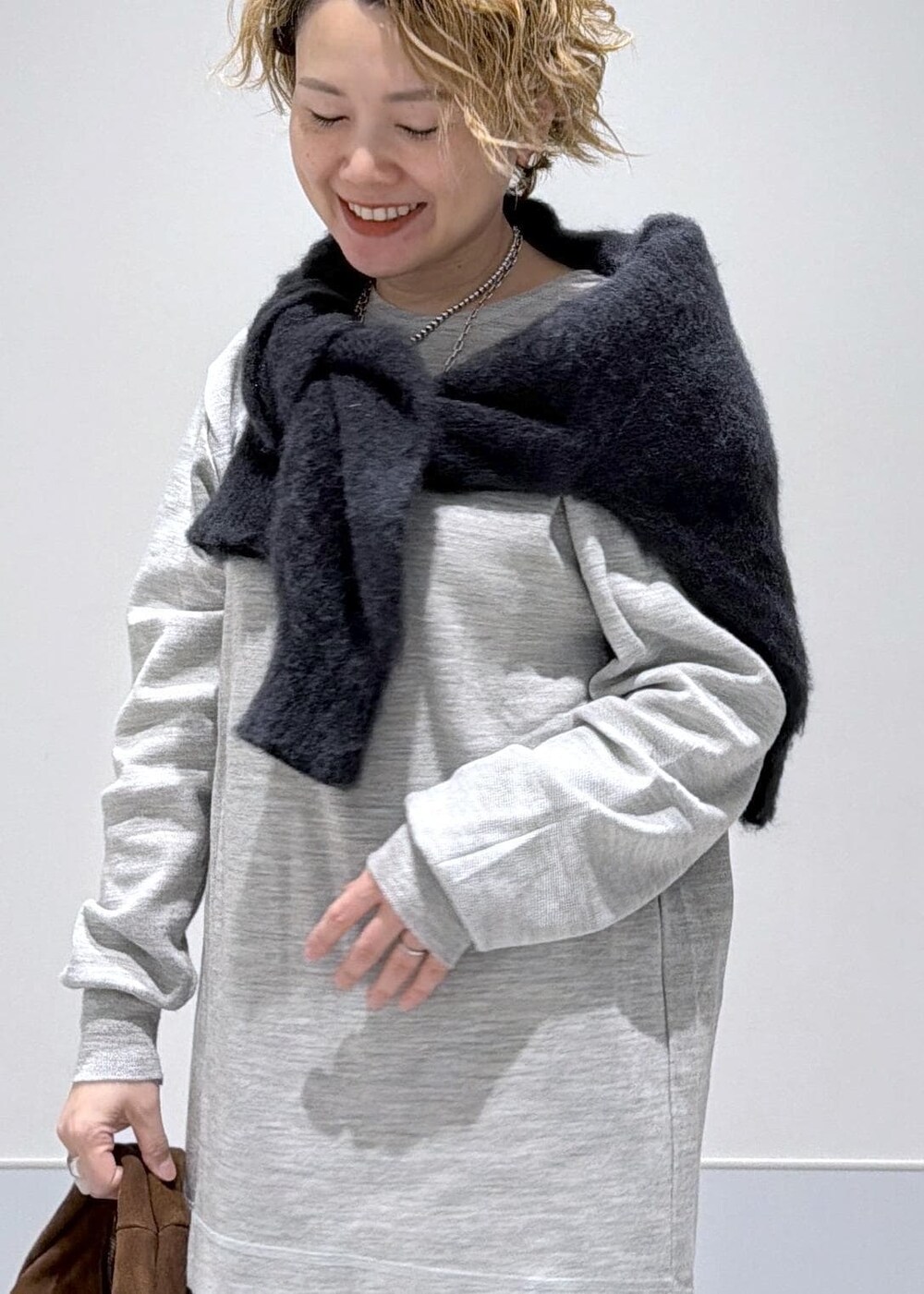 ブラック系のスカート、ブラウン系のハンドバッグ、ブラック系のブーツを着用したレディースの秋コーディネートの5枚目の写真