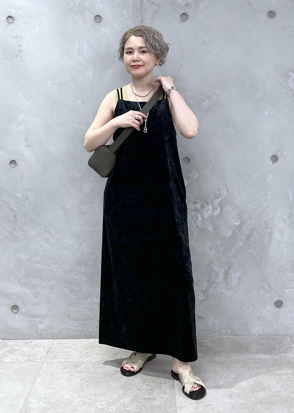 グリーン系のショルダーバッグ、イエロー系のタンクトップ、ブラック系のワンピースを着用したレディースの夏コーディネートの3枚目の写真