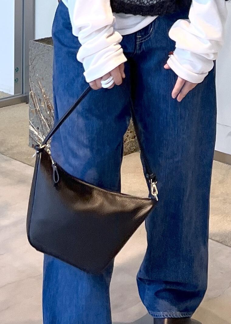 ブルー系のデニムパンツ、ブラック系のハンドバッグ、ブラック系のスニーカーを着用したレディースの秋コーディネートの9枚目の写真