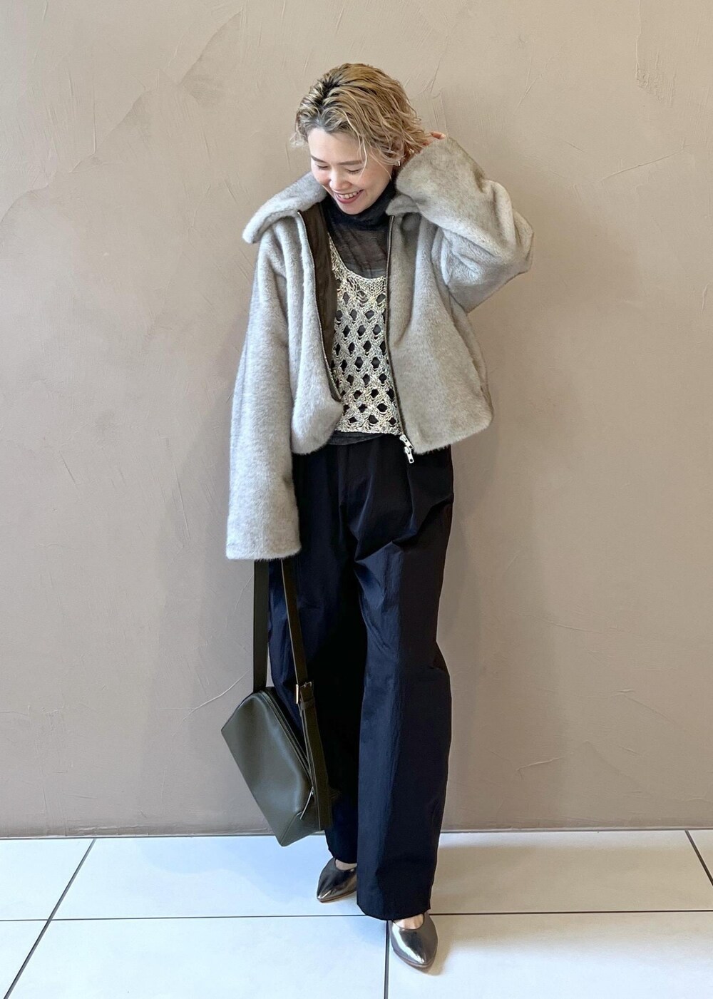 シルバー系のベスト、グレー系のブルゾン、グレー系のニット/セーターを着用したレディースの秋コーディネートの4枚目の写真