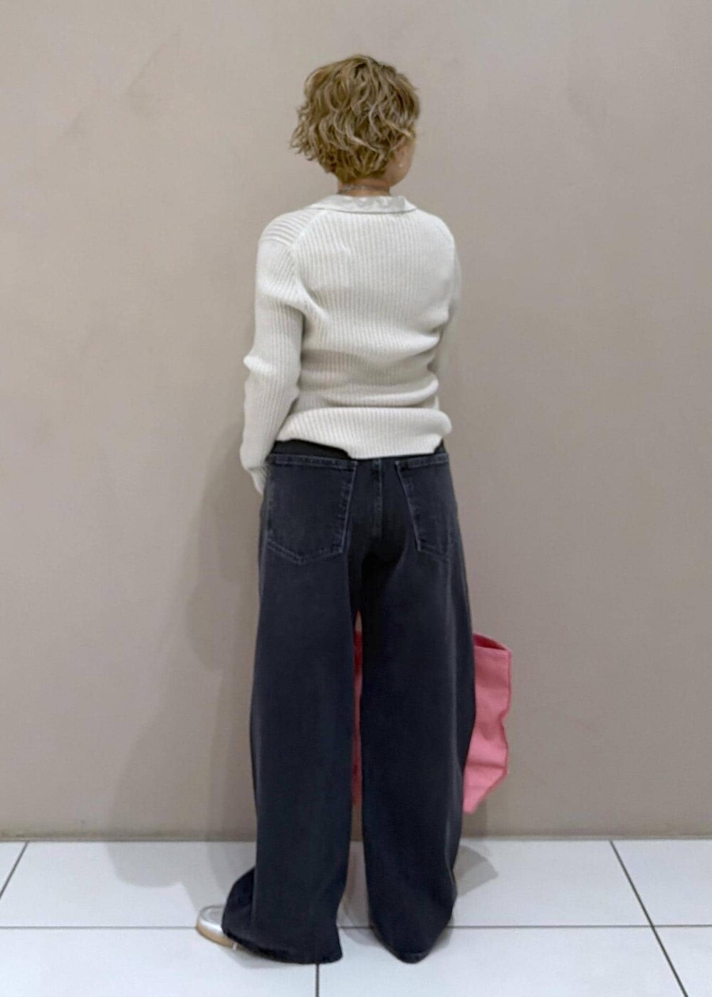 ベージュ系のカーディガン/ボレロ、ピンク系のトートバッグ、ブラック系のデニムパンツを着用したレディースの冬コーディネートの5枚目の写真