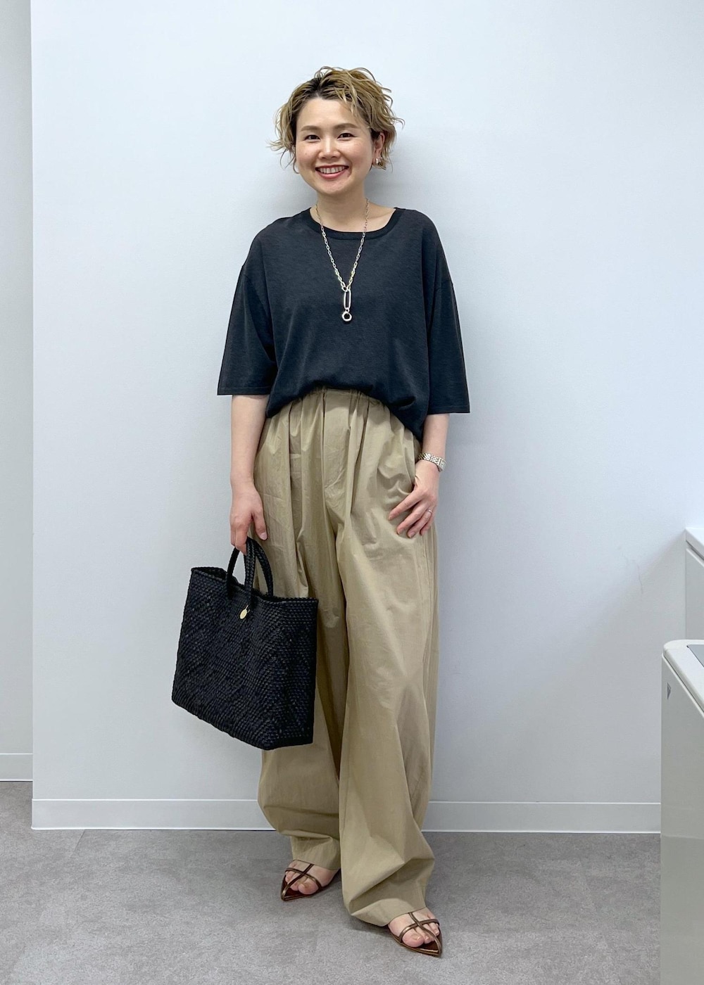 ブラック系のトートバッグ、グレー系のTシャツ/カットソー、その他のサンダルを着用したレディースの春コーディネートの2枚目の写真