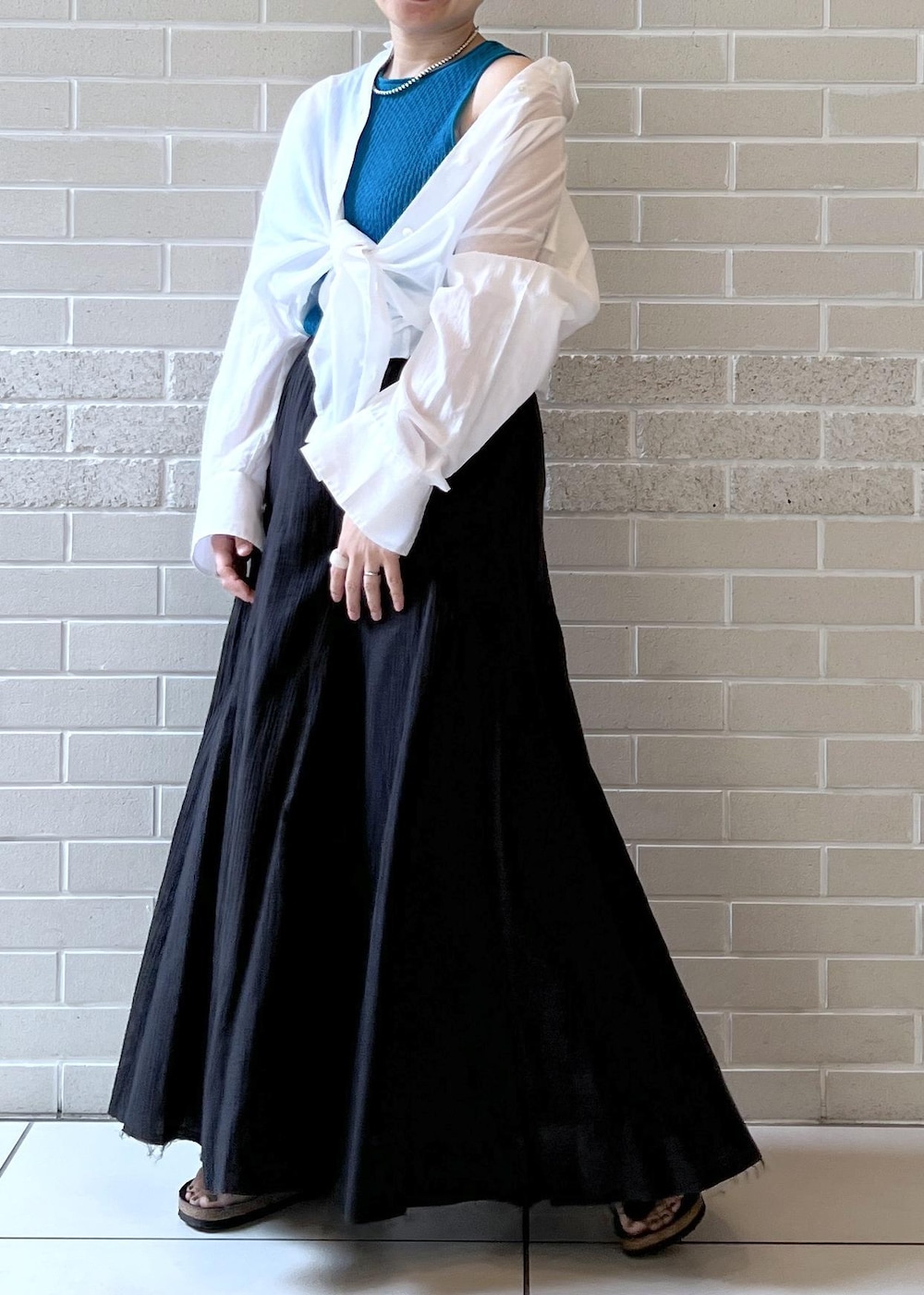 ブラック系のスカート、ホワイト系のシャツ/ブラウス、ブルー系のタンクトップを着用したレディースの夏コーディネートの4枚目の写真