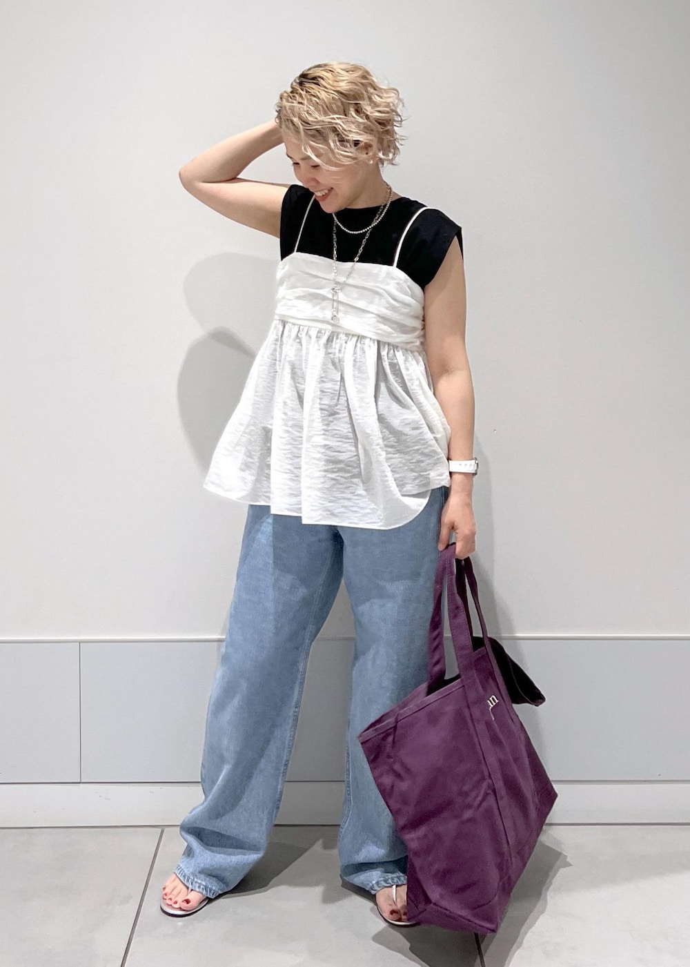 シルバー系のサンダル、ブラック系のTシャツ/カットソー、ホワイト系のキャミソールを着用したレディースの夏コーディネートの3枚目の写真