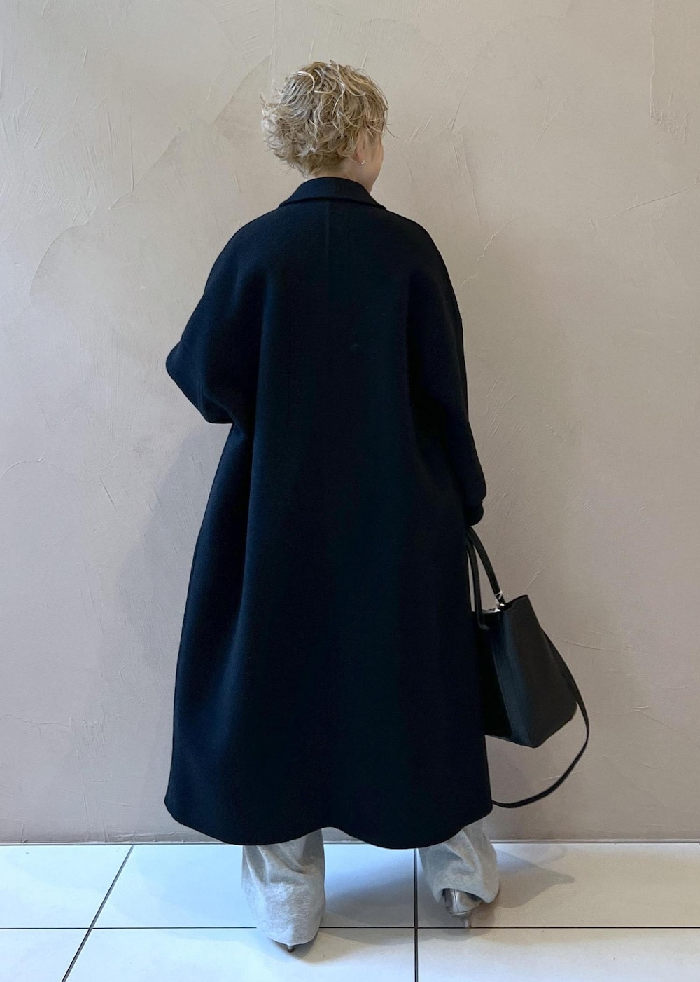 ブラック系のハンドバッグ、ブラック系のその他アウター、シルバー系のパンプスを着用したレディースの秋コーディネートの5枚目の写真