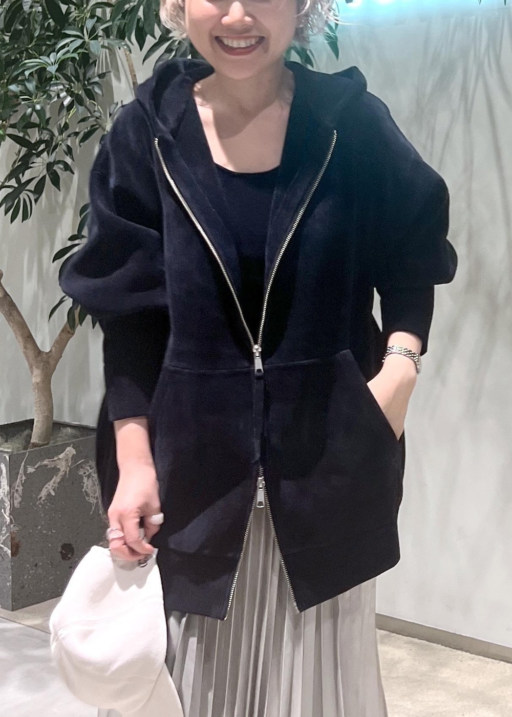 ベージュ系のスカート、ブラック系のタンクトップ、ブラック系のパーカーを着用したレディースの秋コーディネートの7枚目の写真