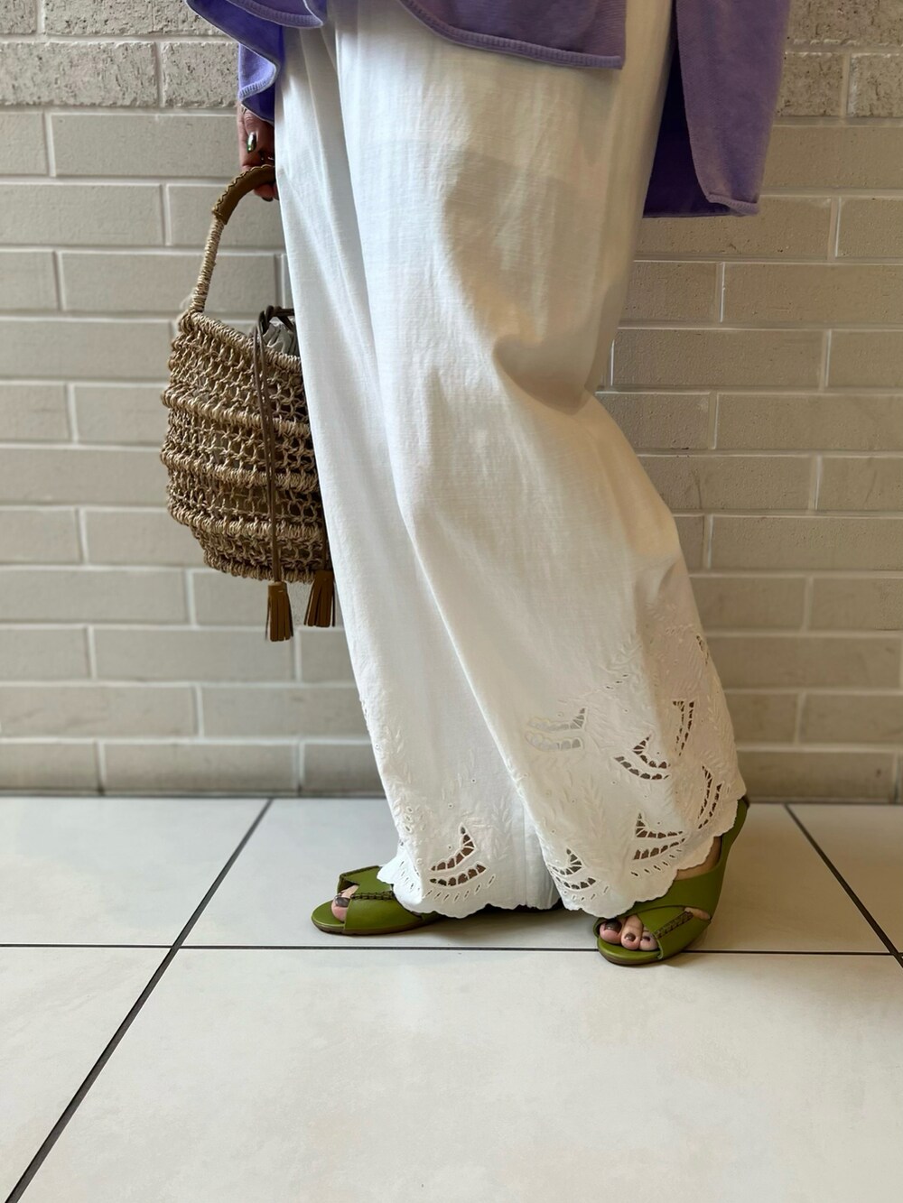 パープル系のパーカー、ホワイト系のその他パンツ、ベージュ系のかごバッグを着用したレディースの春コーディネートの5枚目の写真