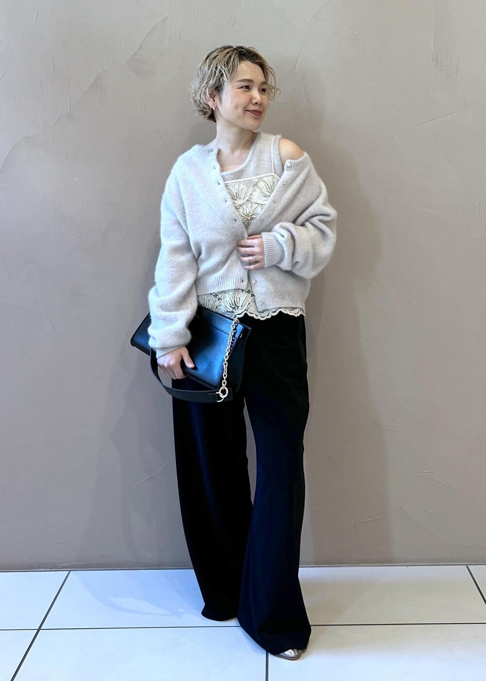 グレー系のタンクトップ、グレー系のカーディガン/ボレロ、ブラック系のショルダーバッグを着用したレディースの冬コーディネートの4枚目の写真