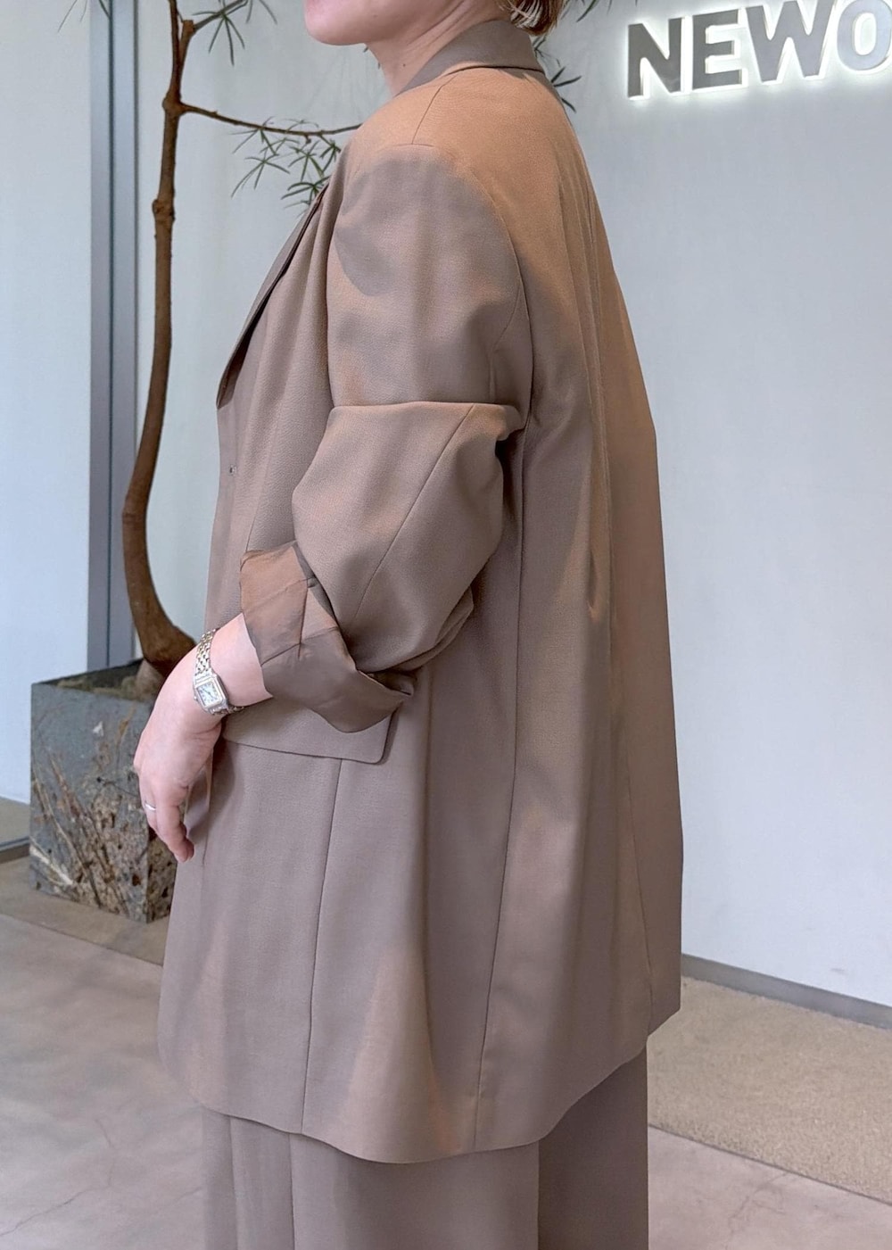 ベージュ系のその他パンツ、ベージュ系のテーラードジャケット、ブラック系のトートバッグを着用したレディースの秋コーディネートの9枚目の写真