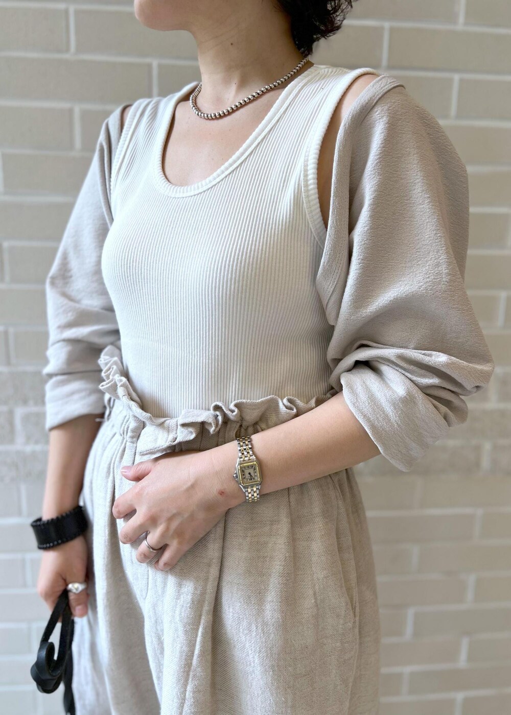 ブラウン系のサンダル、ホワイト系のカーディガン/ボレロ、ホワイト系のスラックスを着用したレディースの夏コーディネートの5枚目の写真