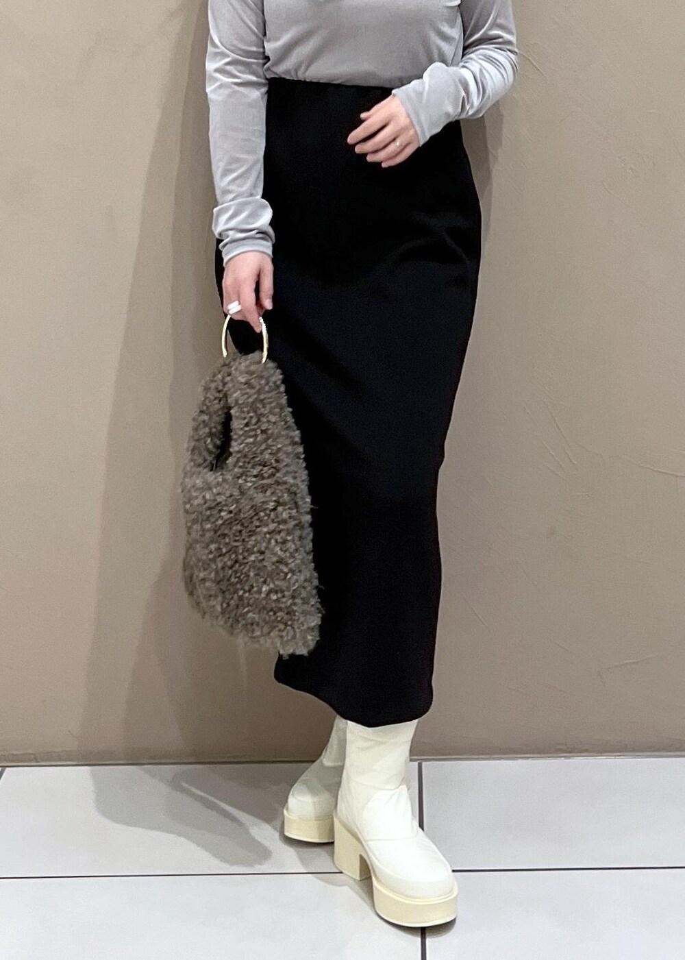 ホワイト系のその他アウター、ブラウン系のハンドバッグ、ブラック系のスカートを着用したレディースの秋コーディネートの6枚目の写真