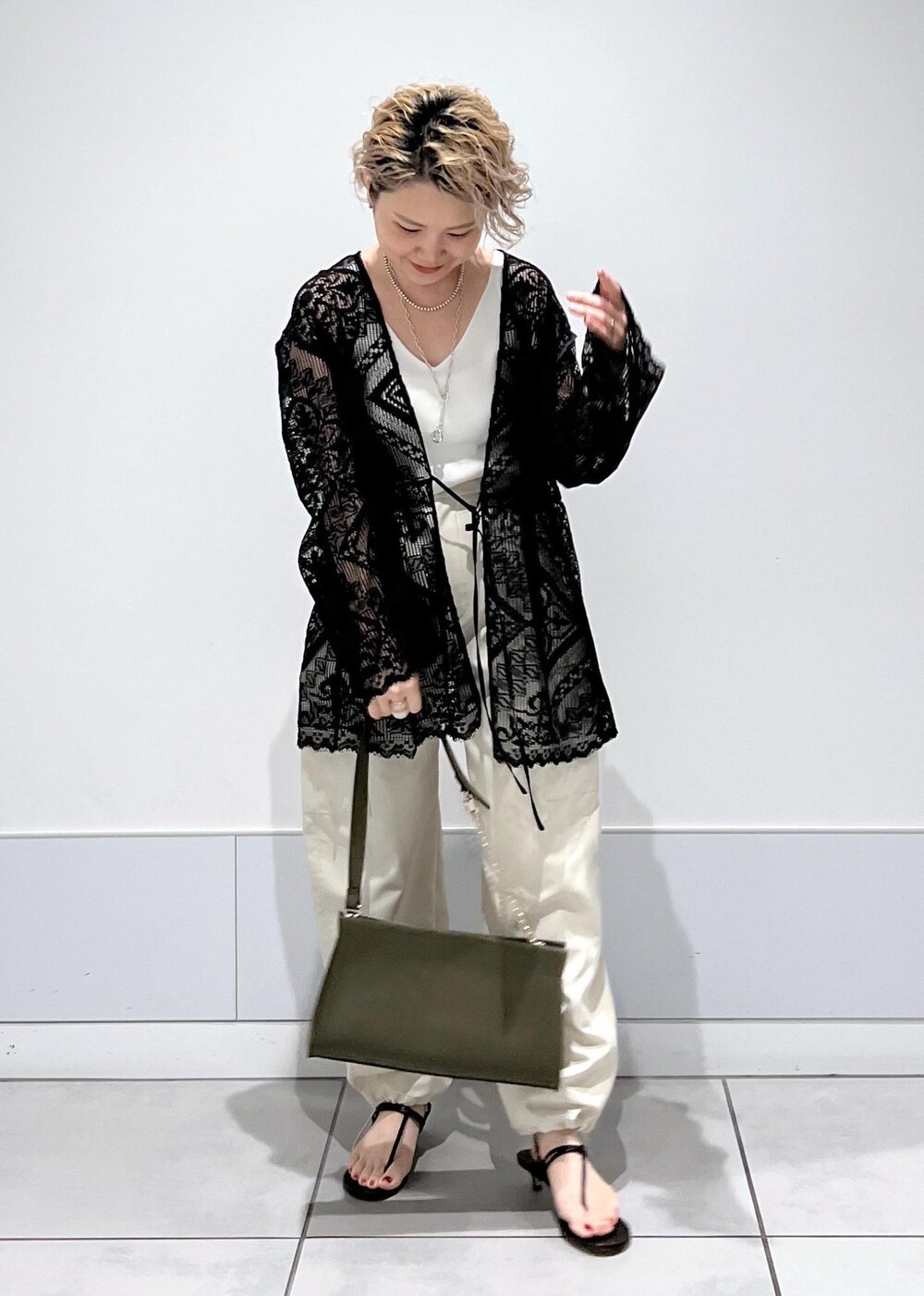 ホワイト系のカーゴパンツ、ホワイト系のキャミソール、ブラック系のノーカラージャケットを着用したレディースの夏コーディネートの4枚目の写真