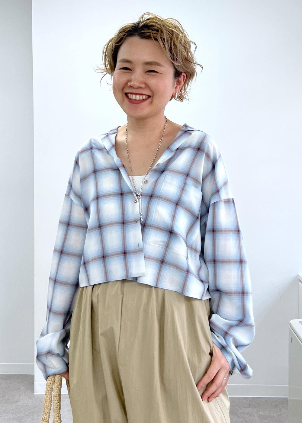 ホワイト系のかごバッグ、その他のサンダル、ベージュ系のその他パンツを着用したレディースの春コーディネートの5枚目の写真