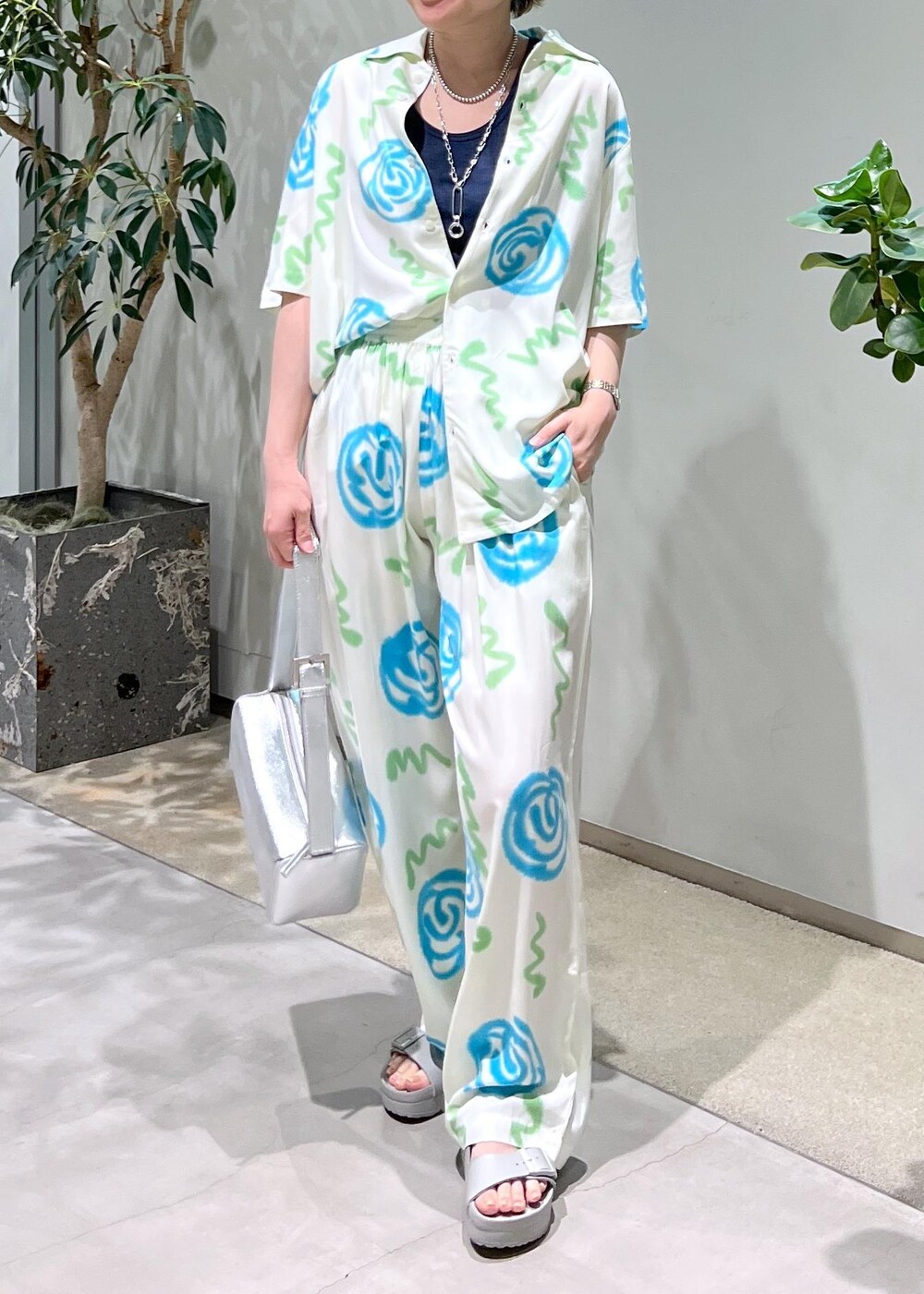 ブルー系のタンクトップ、シルバー系のショルダーバッグ、グレー系のサンダルを着用したレディースの春コーディネートの4枚目の写真