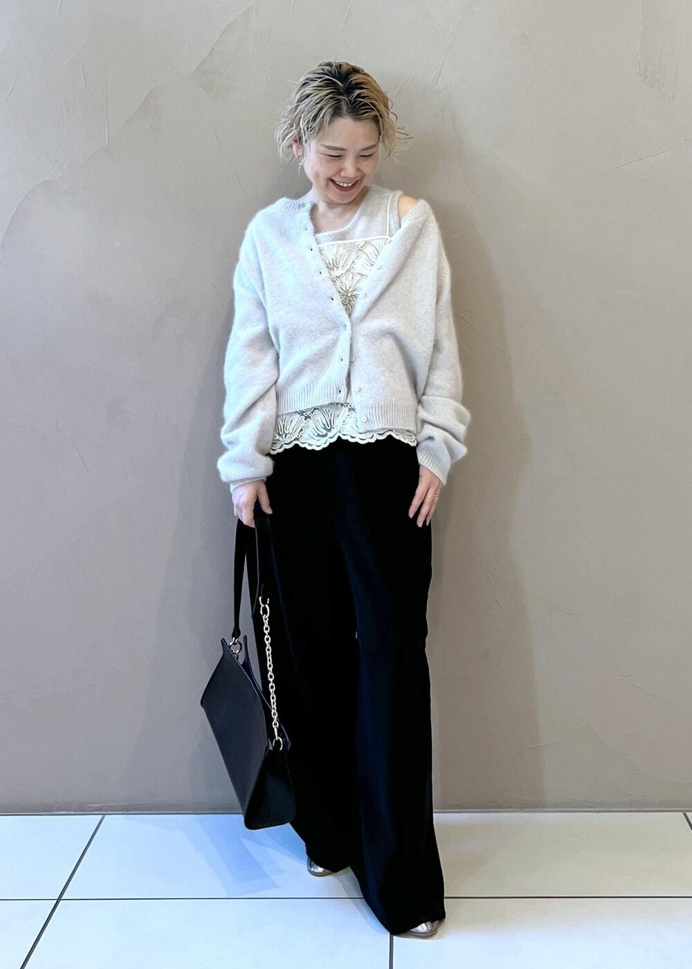 グレー系のタンクトップ、グレー系のカーディガン/ボレロ、ブラック系のショルダーバッグを着用したレディースの冬コーディネートの3枚目の写真