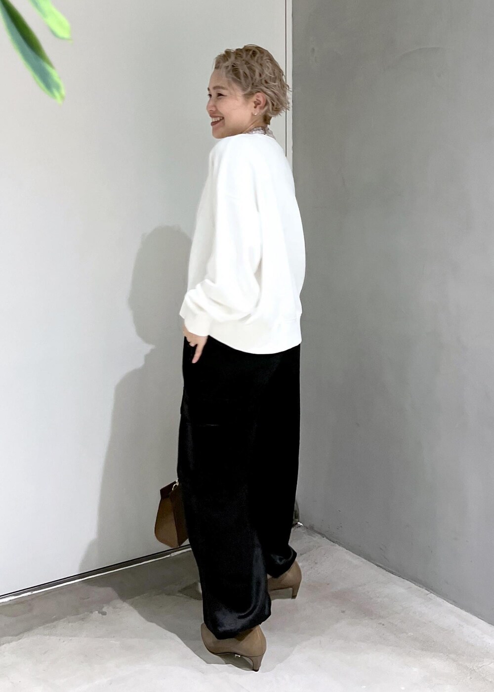 ホワイト系のスウェット、ブラック系のカーゴパンツ、ブラウン系のショルダーバッグを着用したレディースの秋コーディネートの5枚目の写真