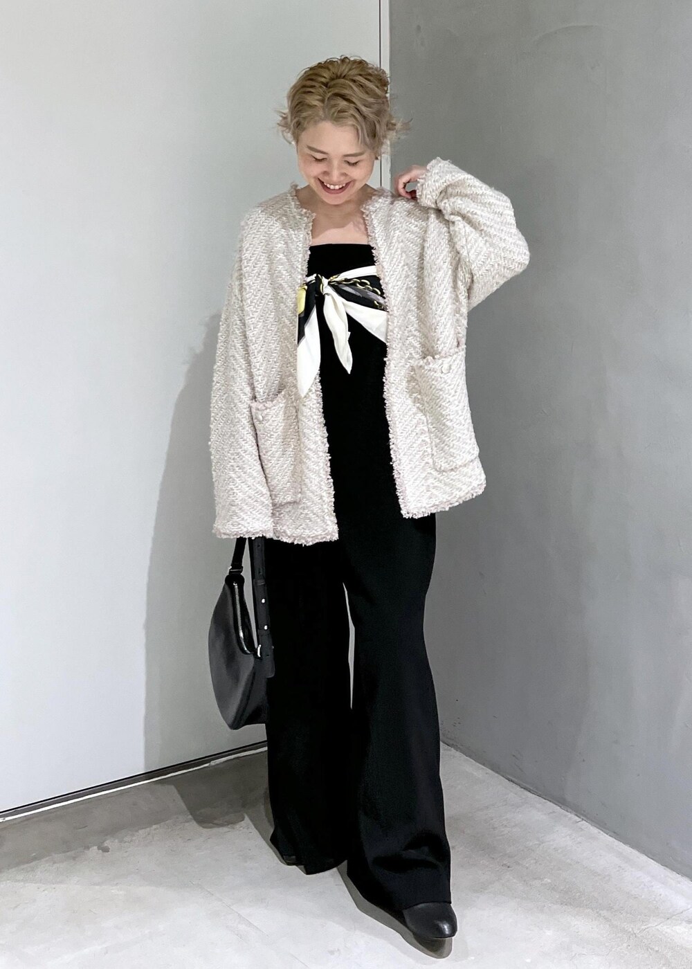 ブラック系のつなぎ/オールインワン、ベージュ系のカーディガン/ボレロ、ブラック系のブーツを着用したレディースの秋コーディネートの2枚目の写真