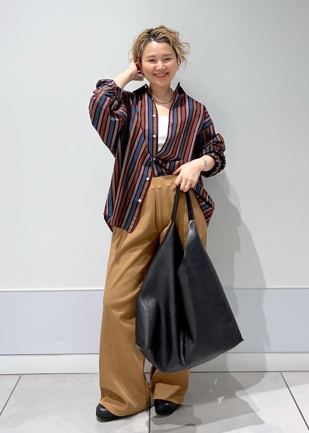 ブラック系のトートバッグ、ブラック系のスニーカー、ブラウン系のその他パンツを着用したレディースの冬コーディネートの3枚目の写真