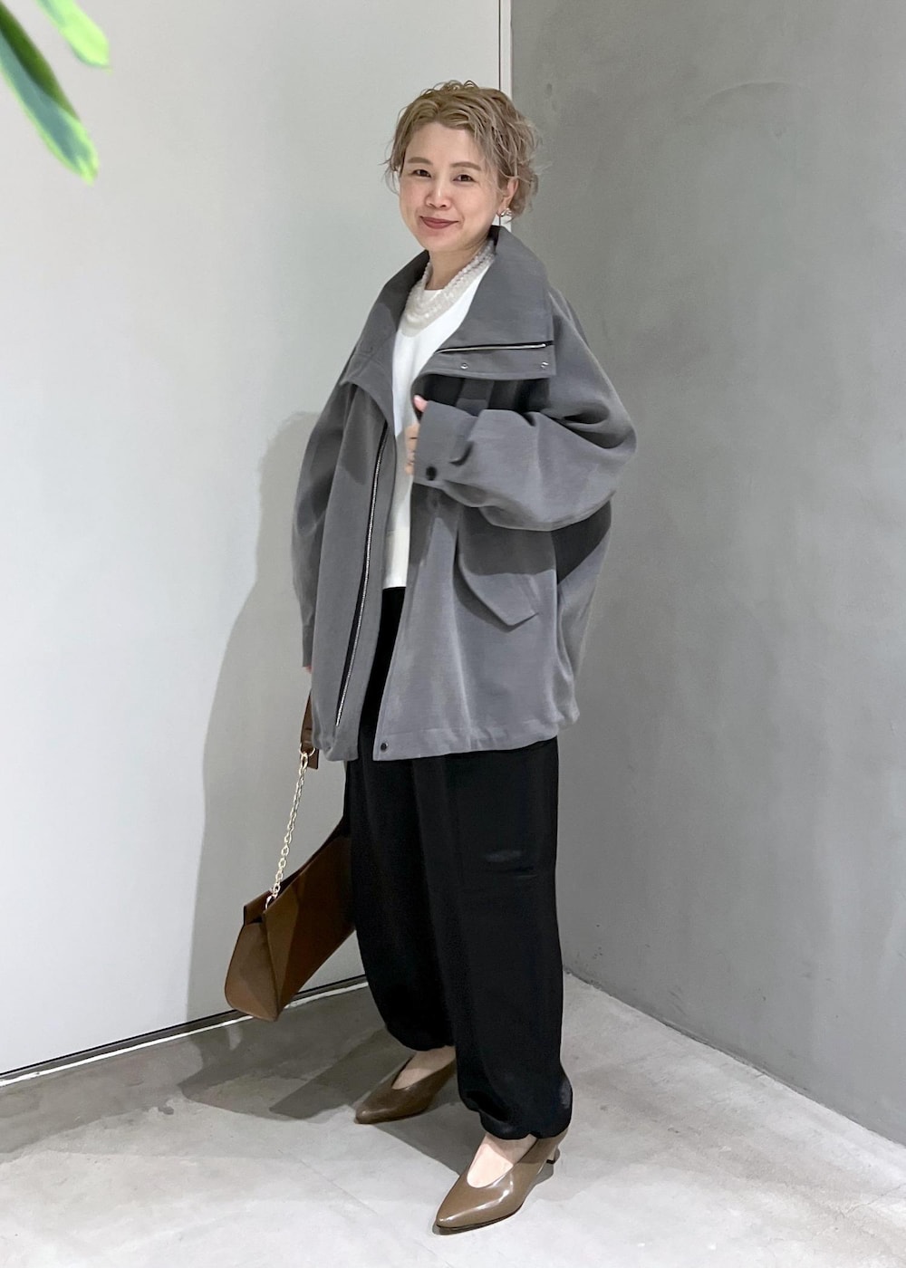 ブラウン系のショルダーバッグ、ブラック系のカーゴパンツ、ホワイト系のスウェットを着用したレディースの秋コーディネートの5枚目の写真