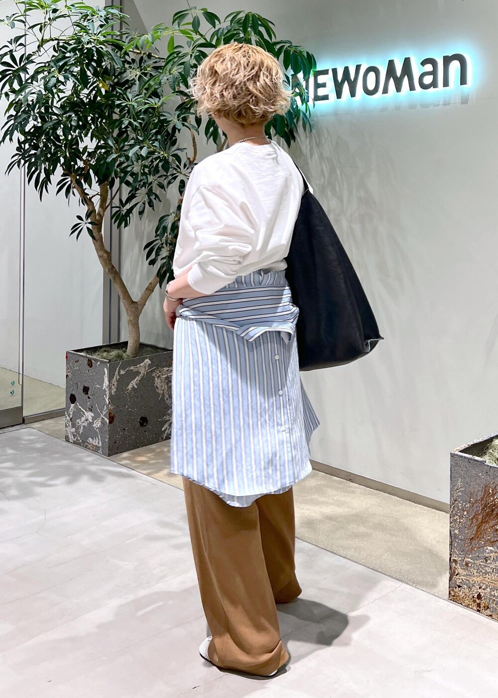 ブラック系のトートバッグ、ブルー系のシャツ/ブラウス、ホワイト系のTシャツ/カットソーを着用したレディースの冬コーディネートの5枚目の写真