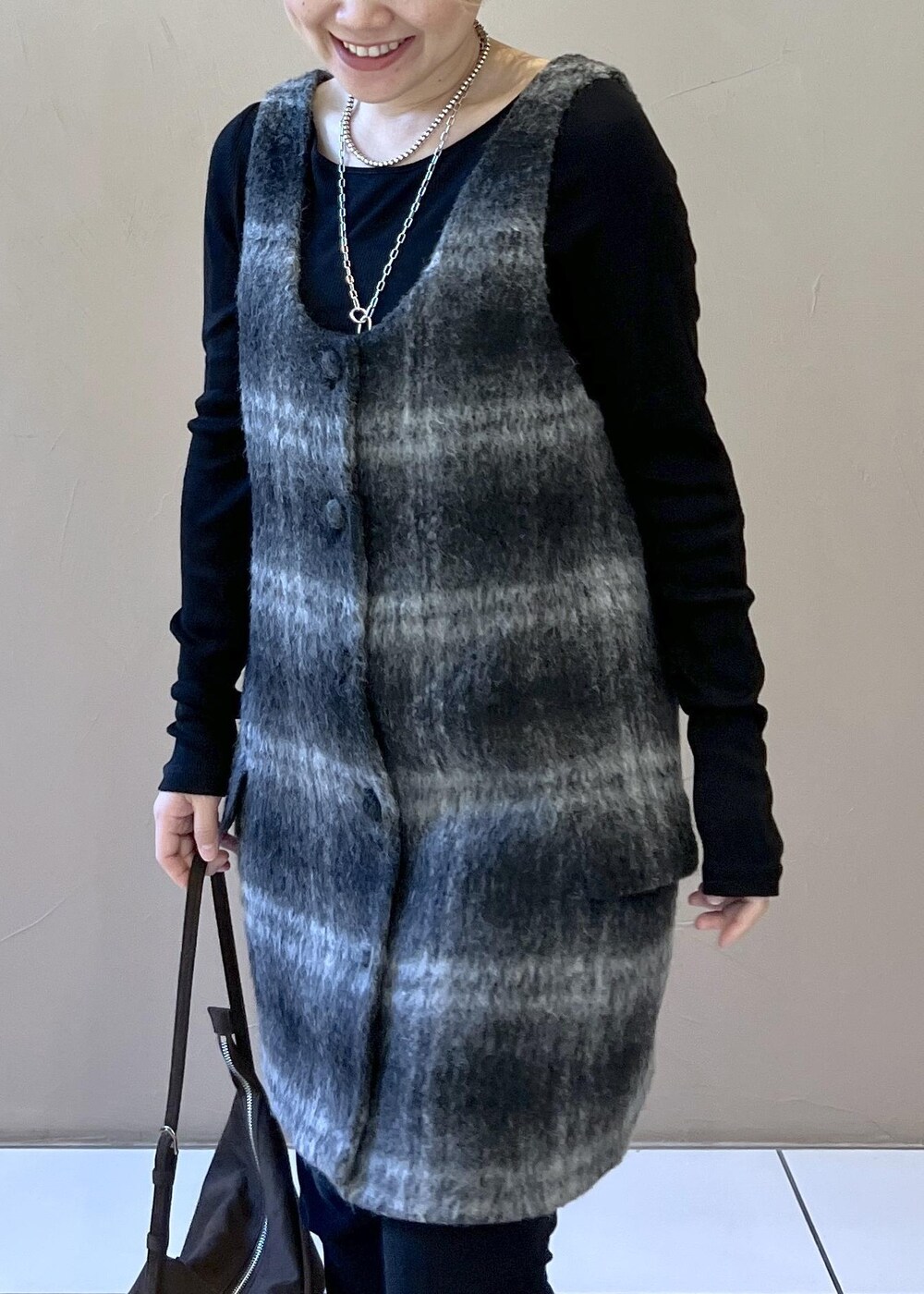 グレー系のジャンパースカート、ブラウン系のショルダーバッグ、ブラック系のTシャツ/カットソーを着用したレディースの秋コーディネートの6枚目の写真