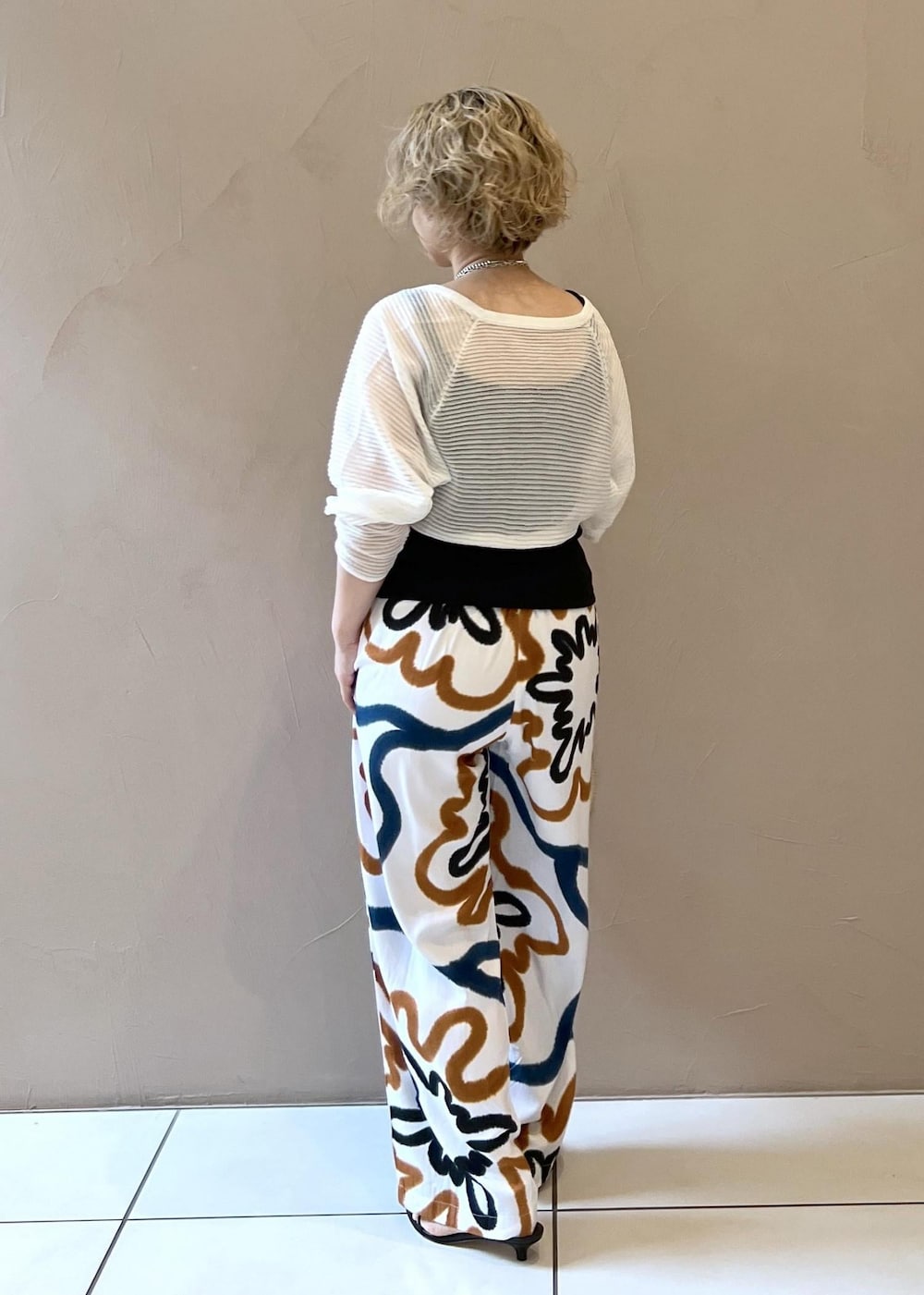 ブラック系のサンダル、ブラック系のタンクトップ、ホワイト系のカーディガン/ボレロを着用したレディースの春コーディネートの5枚目の写真