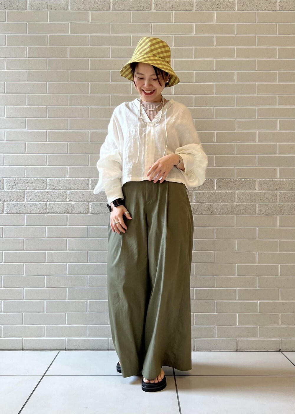 ホワイト系のサンダル、ベージュ系のTシャツ/カットソー、ホワイト系のシャツ/ブラウスを着用したレディースの春コーディネートの3枚目の写真