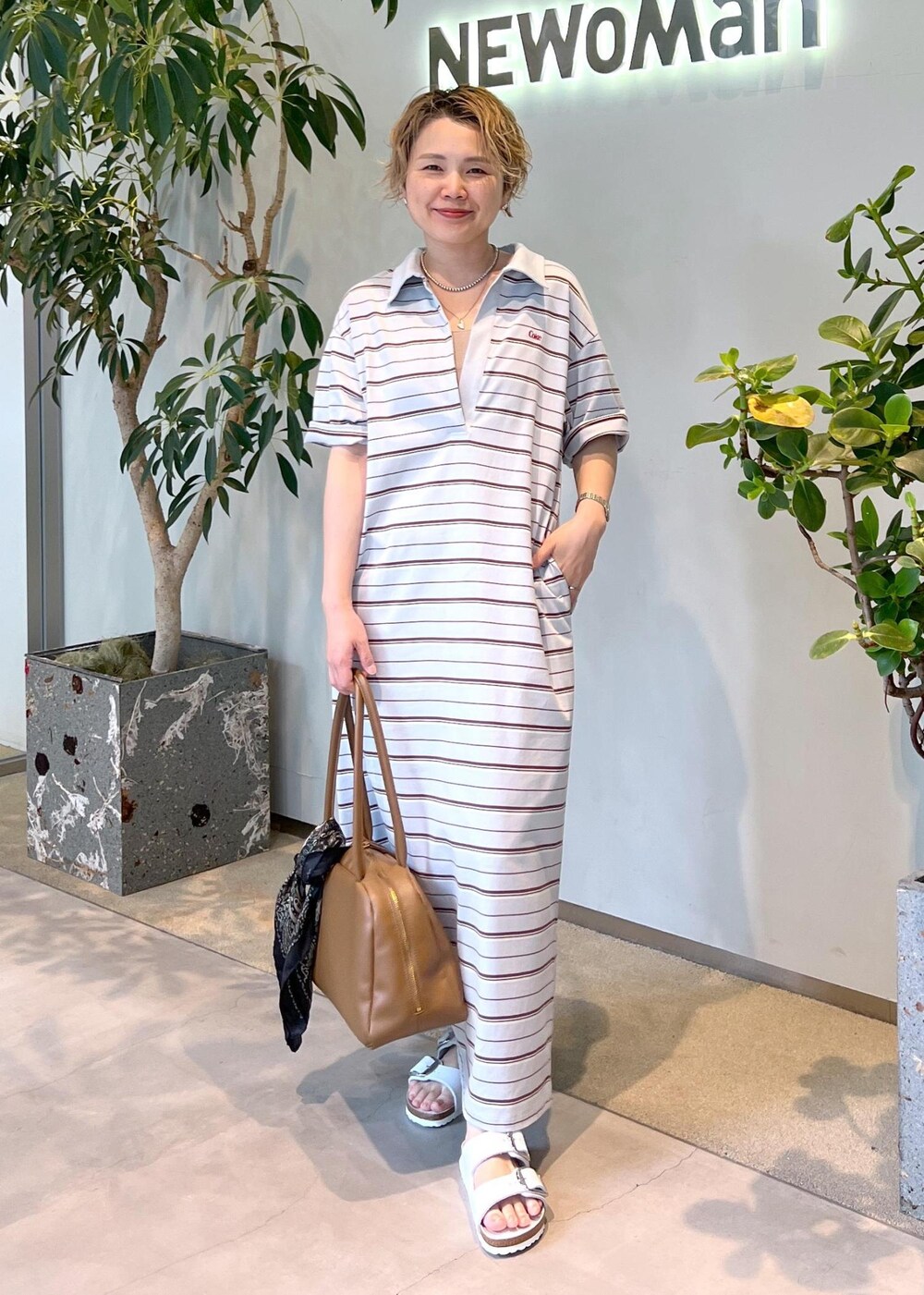 ブラウン系のボストンバッグ、ホワイト系のサンダル、ブルー系のワンピースを着用したレディースの夏コーディネートの3枚目の写真