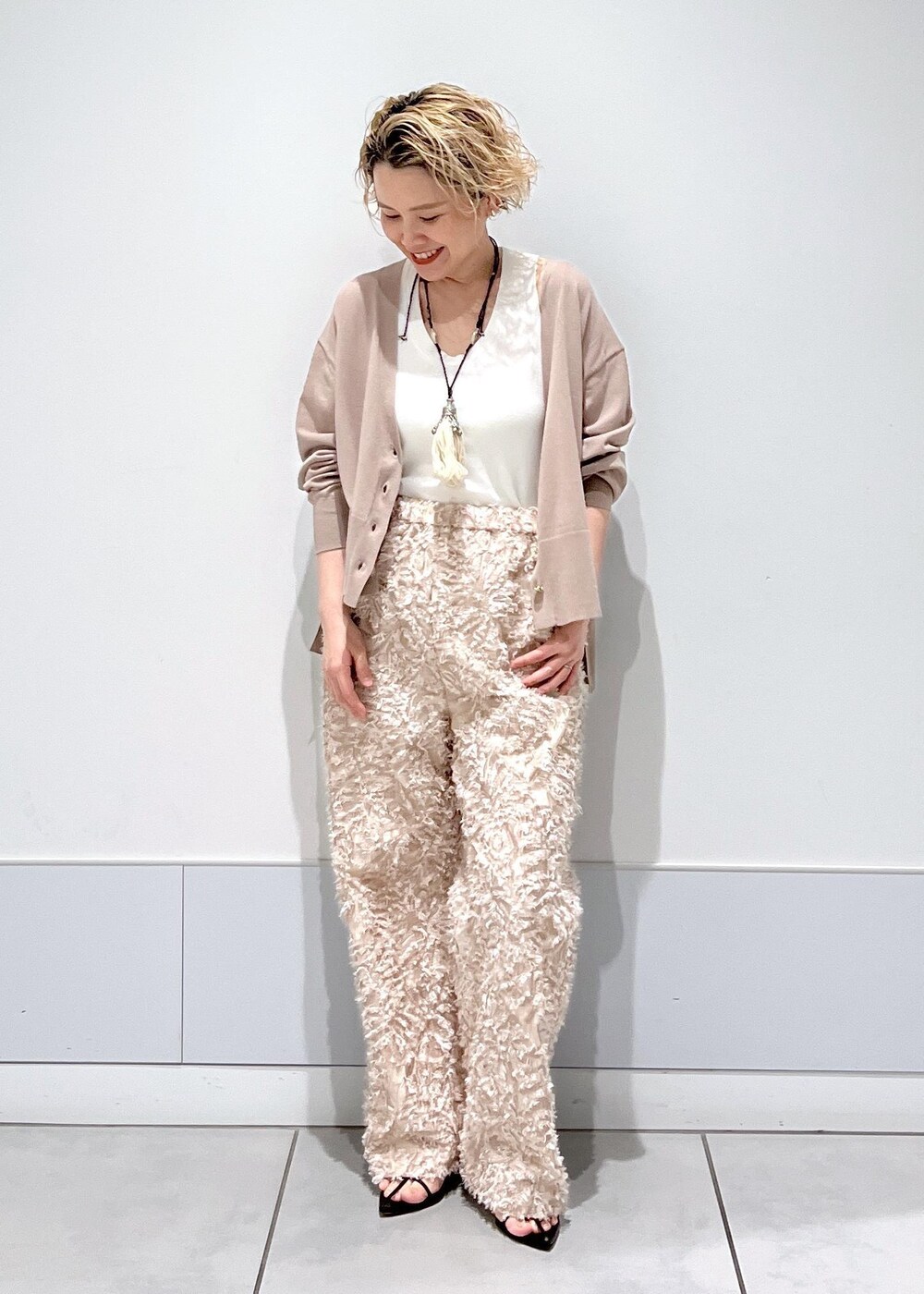 ベージュ系のカーディガン/ボレロ、ブラック系のサンダル、ベージュ系のその他パンツを着用したレディースの春コーディネートの2枚目の写真