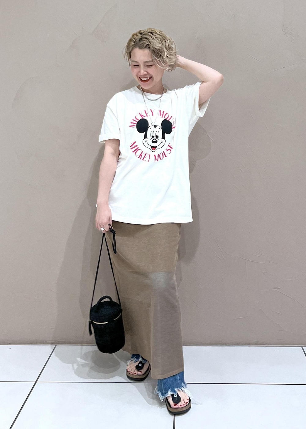 ブラック系のショルダーバッグ、ホワイト系のTシャツ/カットソー、ブルー系のデニムパンツを着用したレディースの夏コーディネートの2枚目の写真