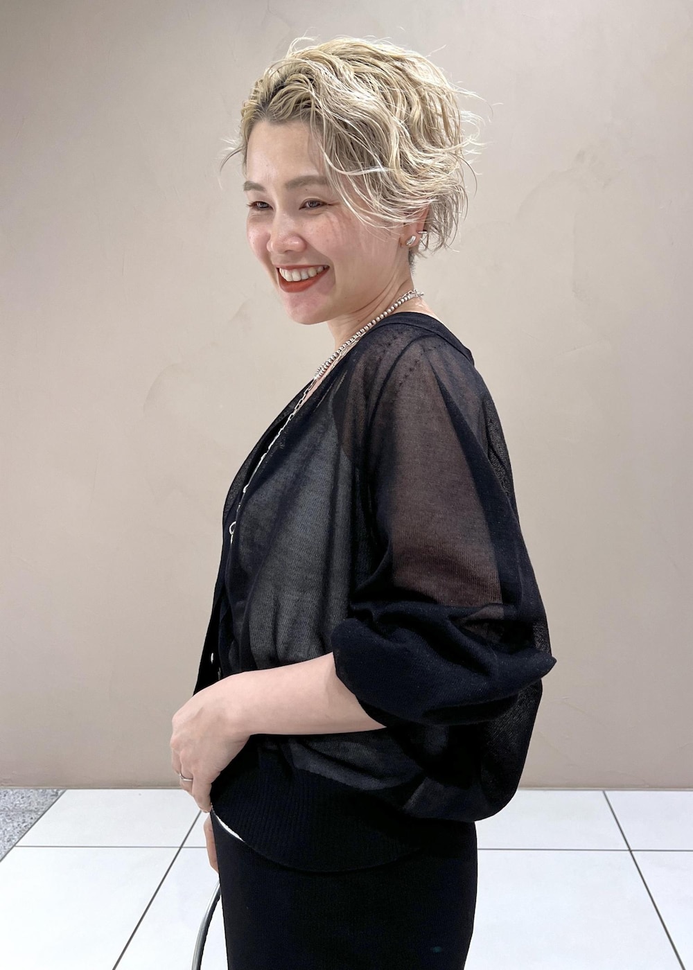 ホワイト系のタンクトップ、ブラック系のカーディガン/ボレロ、ブルー系のデニムパンツを着用したレディースの夏コーディネートの9枚目の写真