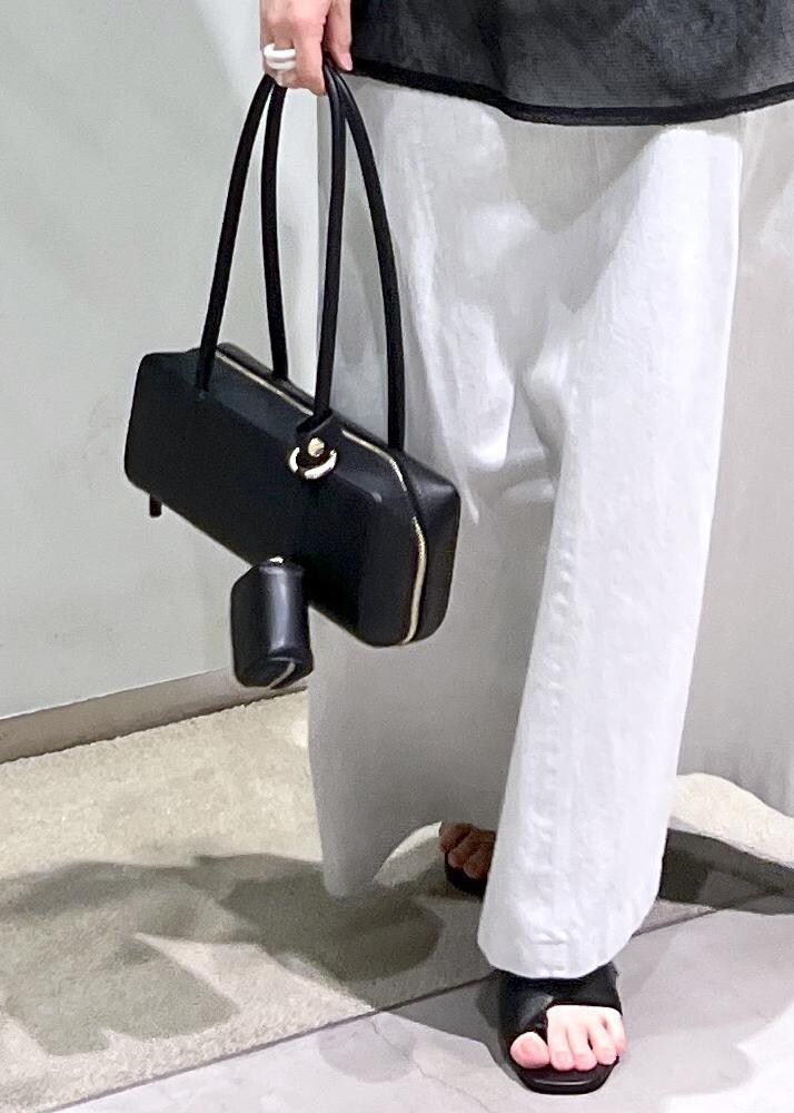 ホワイト系のスカート、ブラック系のサンダル、ブラック系のショルダーバッグを着用したレディースの夏コーディネートの7枚目の写真