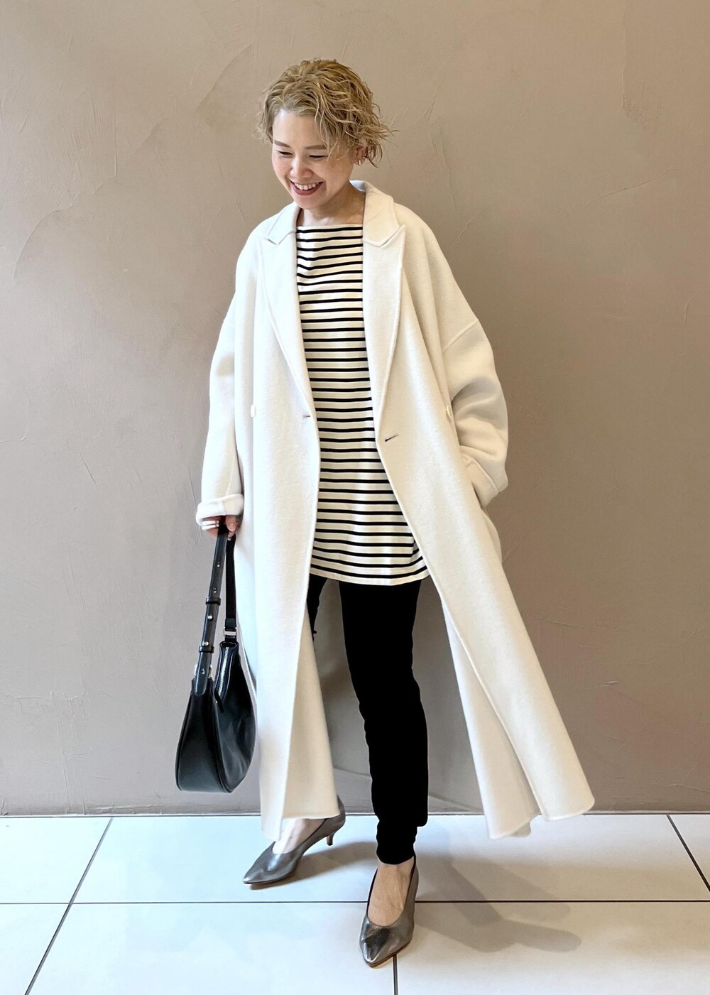 ホワイト系のその他アウター、シルバー系のパンプス、ブラック系のその他パンツを着用したレディースの秋コーディネートの4枚目の写真