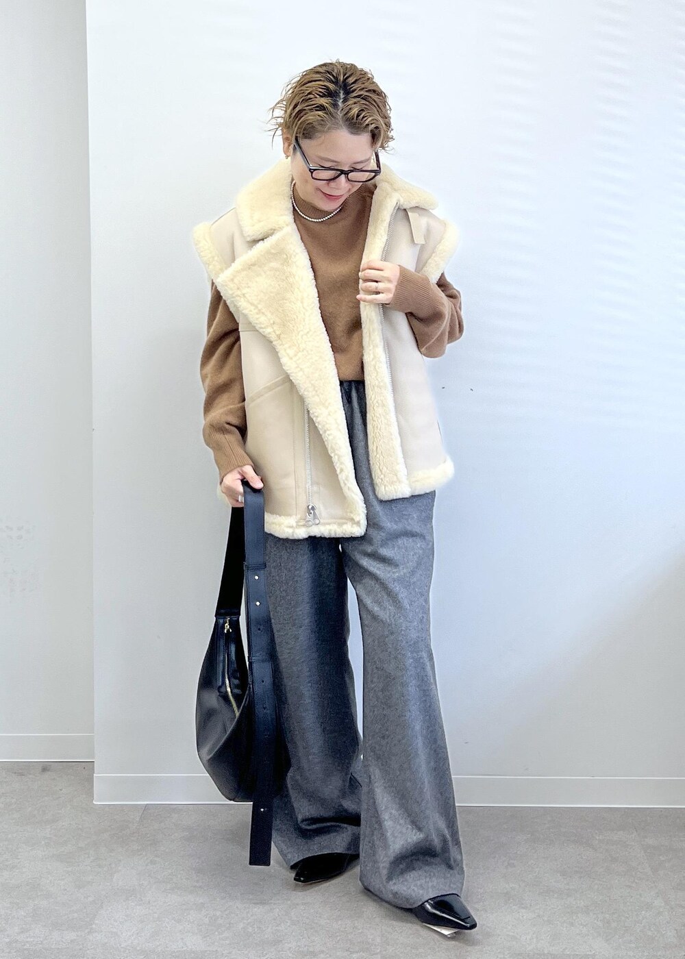 ブラック系のショルダーバッグ、グレー系のその他パンツ、ブラウン系のニット/セーターを着用したレディースの秋コーディネートの2枚目の写真