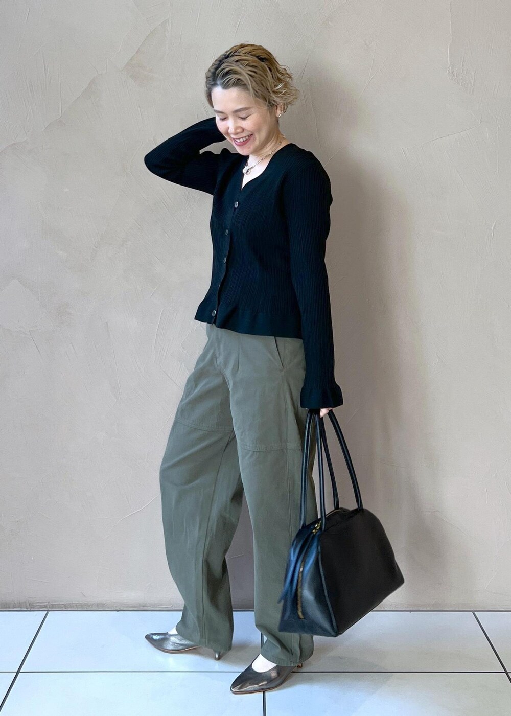 ブラック系のカーディガン/ボレロ、グリーン系のその他パンツ、ブラック系のボストンバッグを着用したレディースの冬コーディネートの4枚目の写真