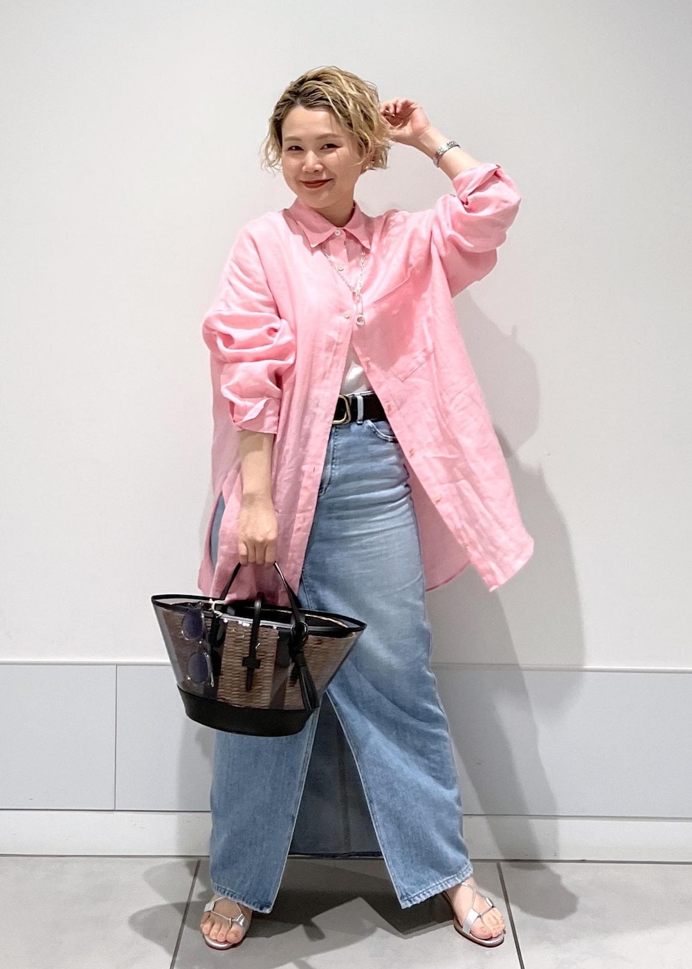 ピンク系のシャツ/ブラウス、ホワイト系のかごバッグ、ブルー系のデニムスカートを着用したレディースの春コーディネートの5枚目の写真