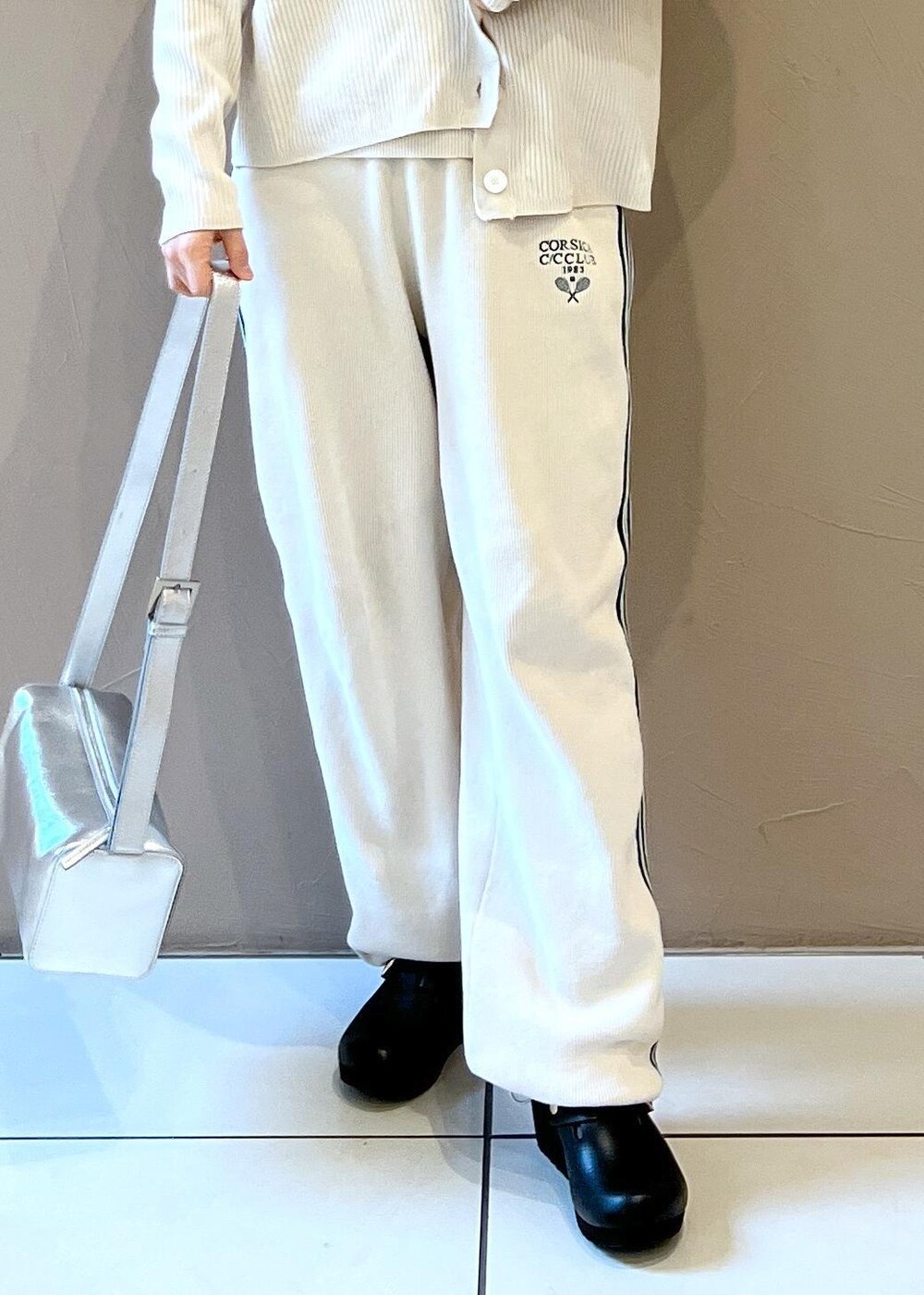 シルバー系のショルダーバッグ、ホワイト系のカーディガン/ボレロ、ホワイト系のその他パンツを着用したレディースの冬コーディネートの6枚目の写真