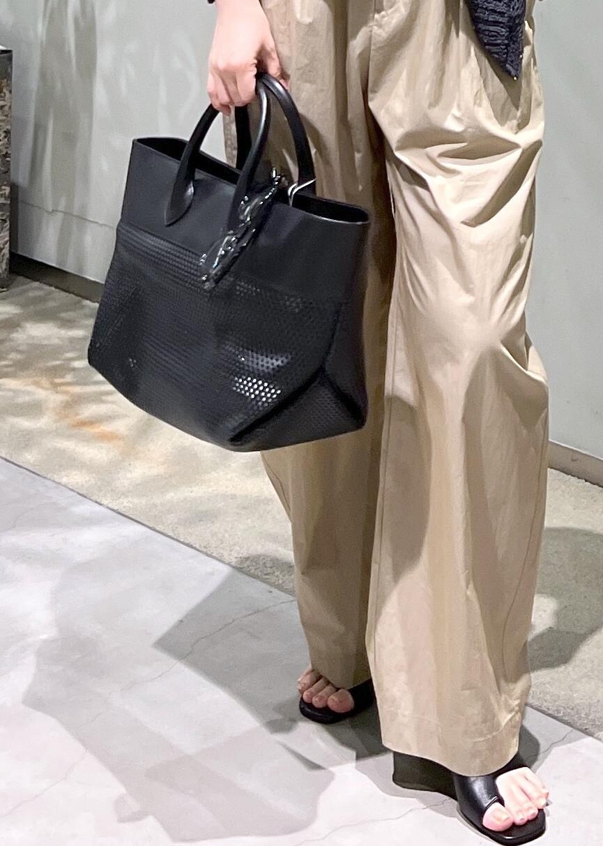 ブラック系のトートバッグ、ブラック系のサンダル、グレー系のカーディガン/ボレロを着用したレディースの春コーディネートの6枚目の写真