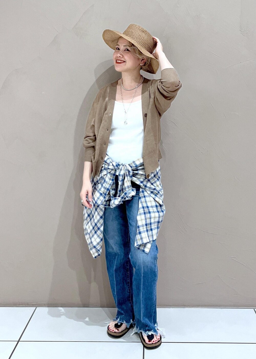 ホワイト系のタンクトップ、ゴールド系のカーディガン/ボレロ、ブルー系のデニムパンツを着用したレディースの夏コーディネートの8枚目の写真