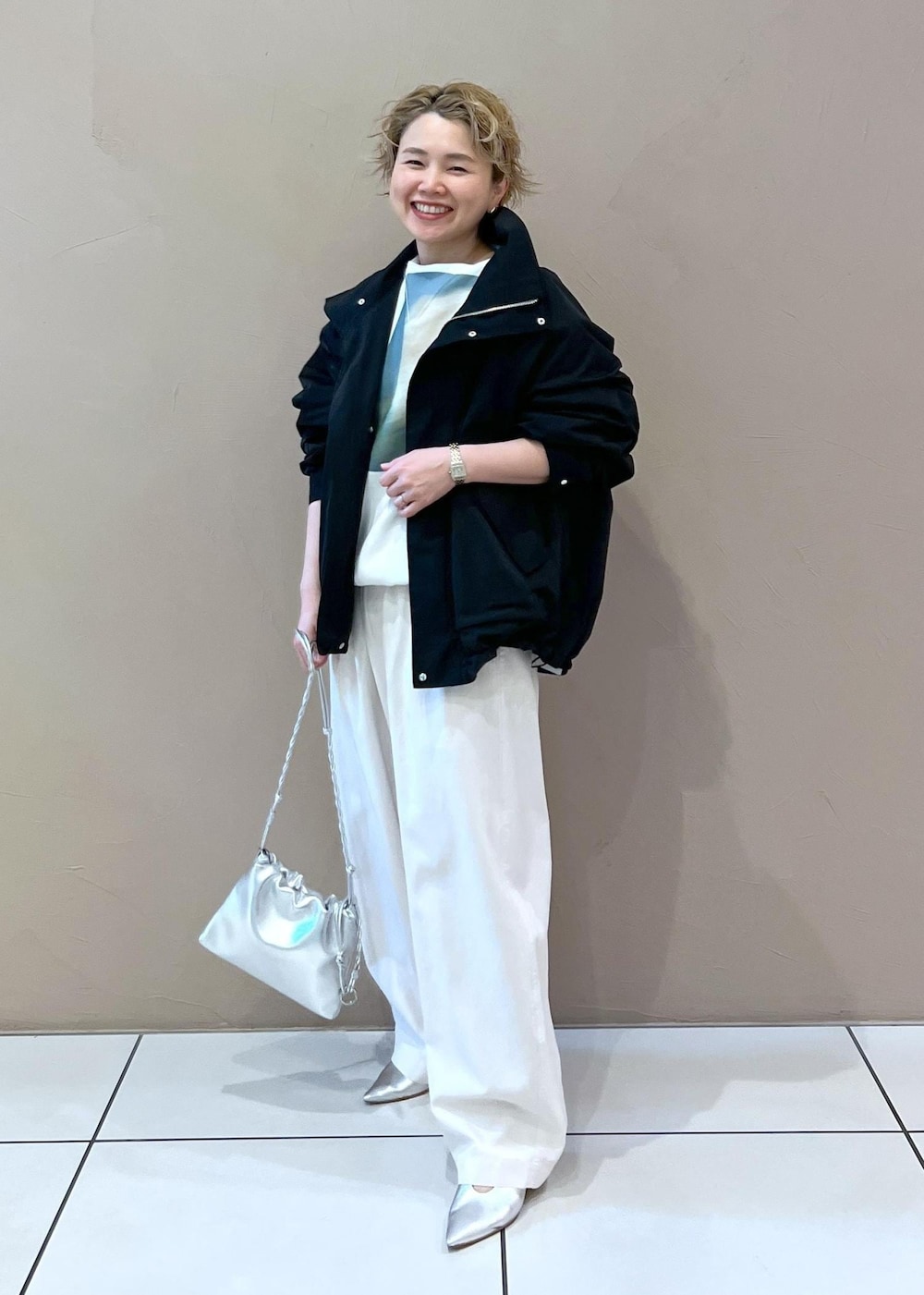 ブラック系のブルゾン、ホワイト系のその他パンツ、シルバー系のショルダーバッグを着用したレディースの春コーディネートの3枚目の写真