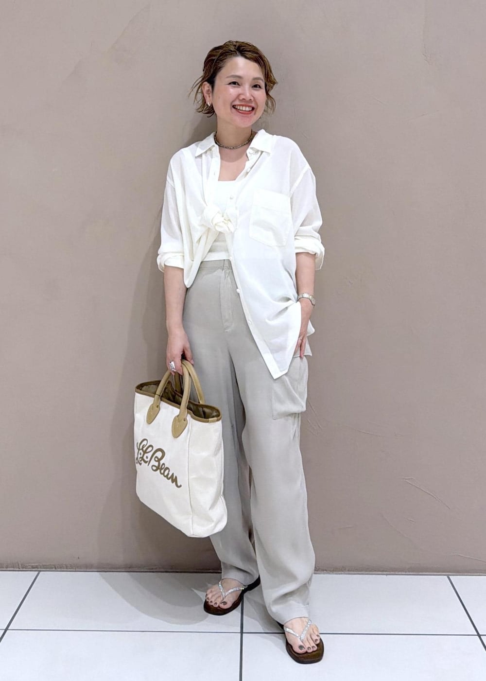 ブラウン系のサンダル、ベージュ系のその他パンツ、ホワイト系のシャツ/ブラウスを着用したレディースの夏コーディネートの2枚目の写真