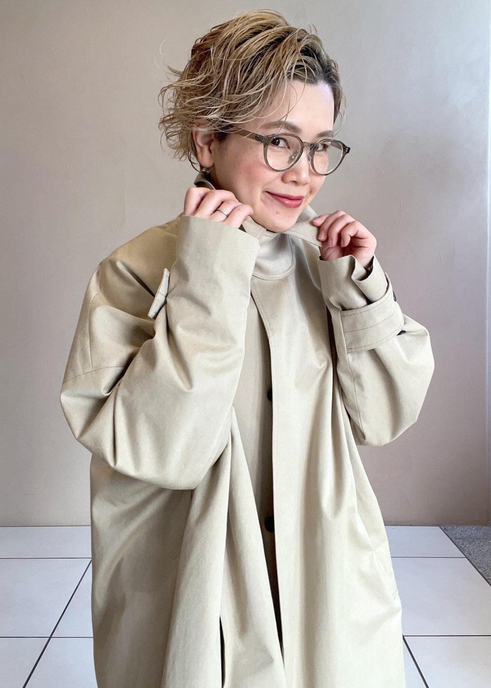 ホワイト系のニット/セーター、ベージュ系のステンカラーコート、ホワイト系のその他パンツを着用したレディースの冬コーディネートの5枚目の写真