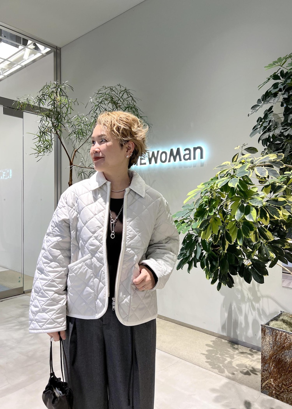 ピンク系のブルゾン、ブラウン系のハンドバッグ、ブラック系のパンプスを着用したレディースの秋コーディネートの6枚目の写真