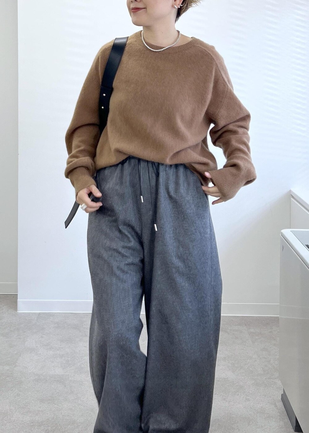 ブラック系のショルダーバッグ、グレー系のその他パンツ、ブラウン系のニット/セーターを着用したレディースの秋コーディネートの5枚目の写真