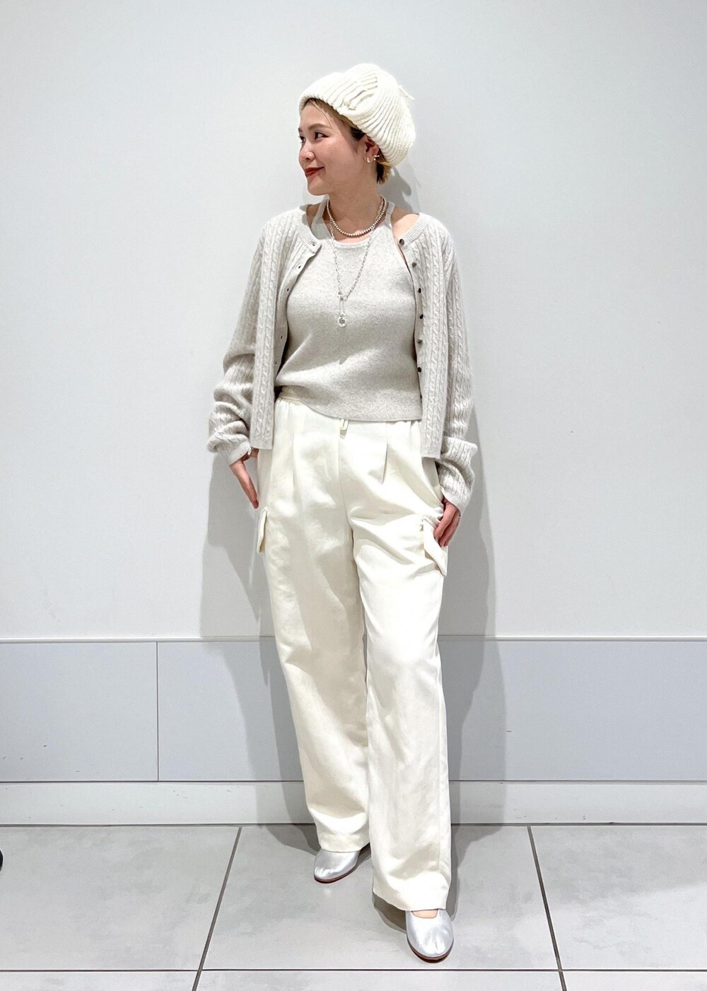 ホワイト系のカーゴパンツ、ホワイト系のキャミソール、ホワイト系のカーディガン/ボレロを着用したレディースの冬コーディネートの2枚目の写真