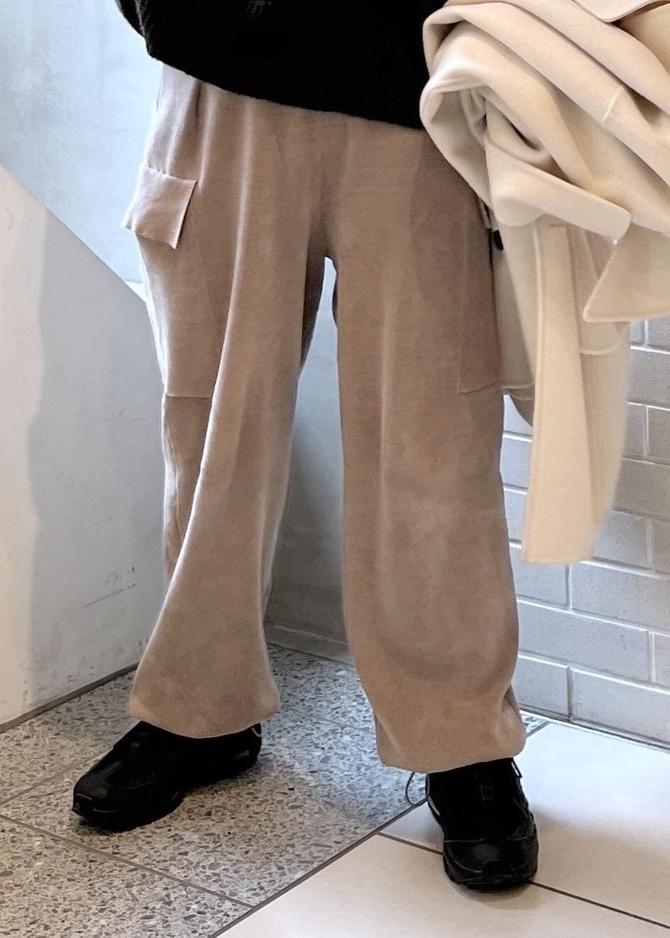 ホワイト系のピーコート、グレー系のカーゴパンツ、ブラウン系のニット/セーターを着用したレディースの秋コーディネートの6枚目の写真