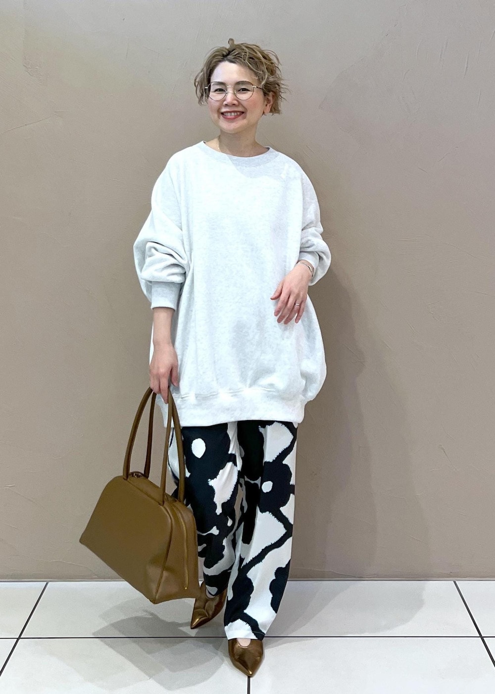 グレー系のスウェット、その他のパンプス、ブラウン系のボストンバッグを着用したレディースの春コーディネートの4枚目の写真