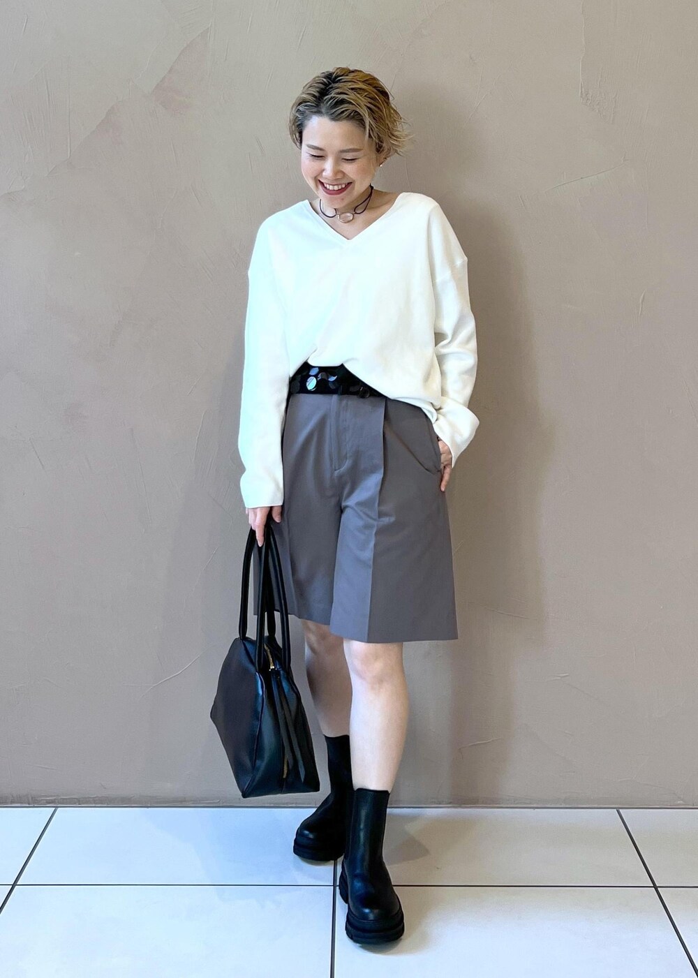 ブラック系のブーツ、ホワイト系のニット/セーター、グレー系のその他パンツを着用したレディースの冬コーディネートの4枚目の写真