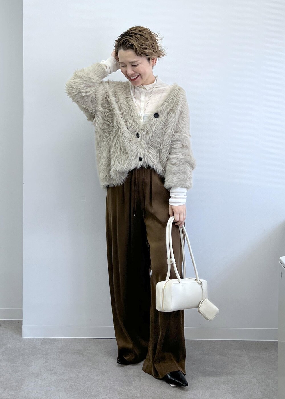 ベージュ系のカーディガン/ボレロ、ブラウン系のその他パンツ、ホワイト系のショルダーバッグを着用したレディースの秋コーディネートの3枚目の写真